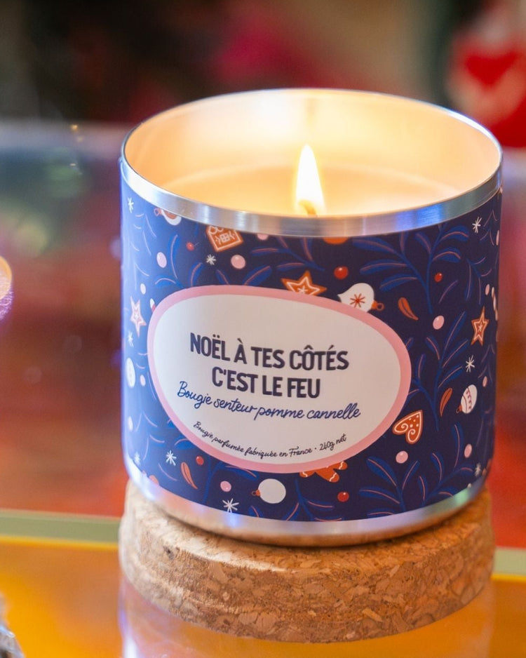 Bougie festive avec étiquette humoristique sur fond neutre