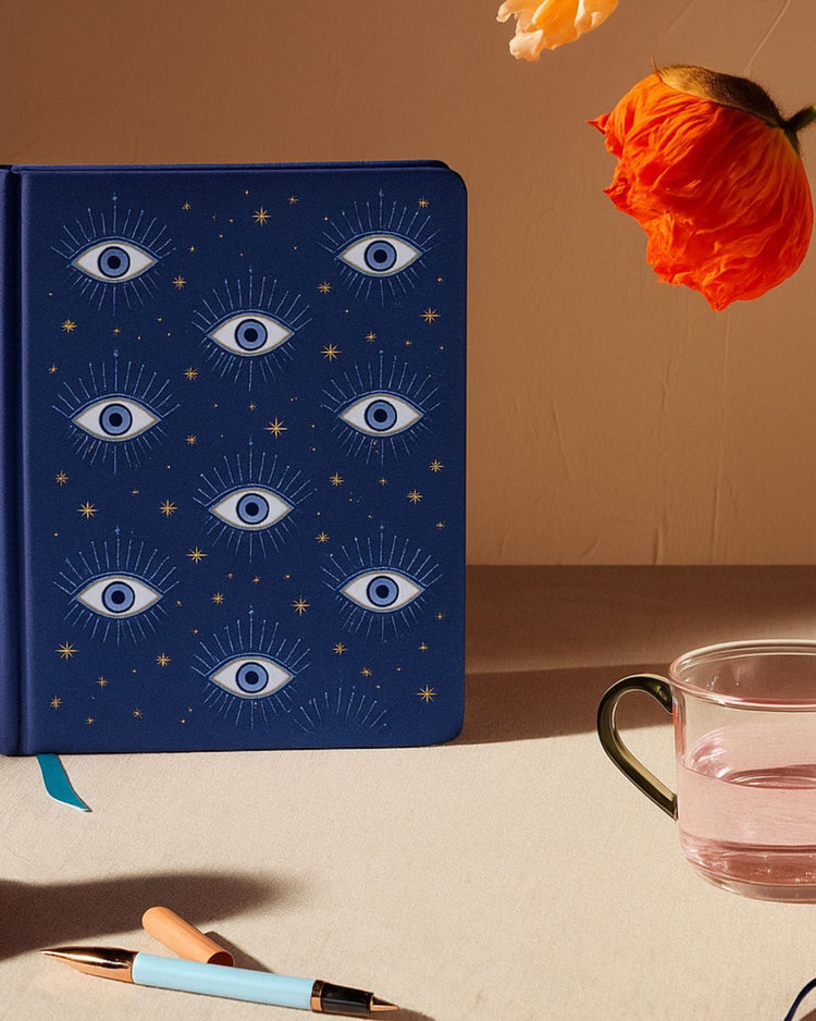 Carnet avec motifs d'yeux sur fond blanc, aspect brillant.