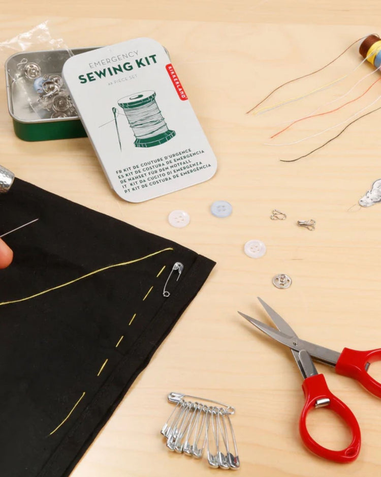 Kit de secours couture avec accessoires variés sur fond neutre