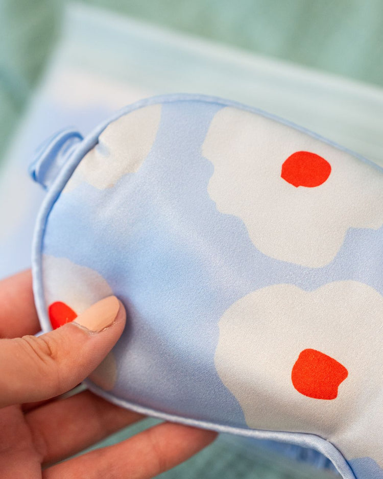 Masque de sommeil fleuri en tissu satiné, vue de face.