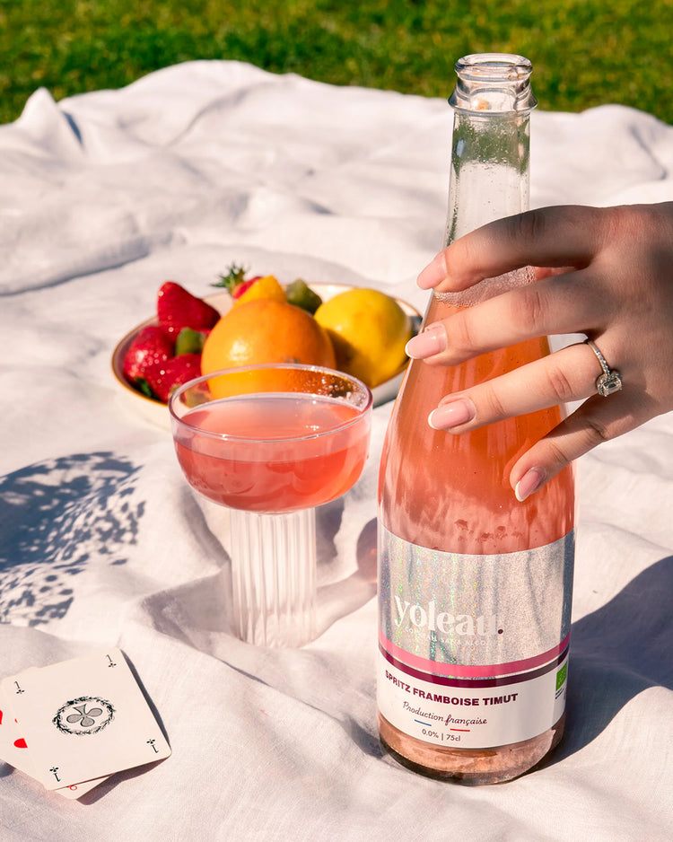 Bouteille de spritz framboise sur fond clair, étiquette colorée