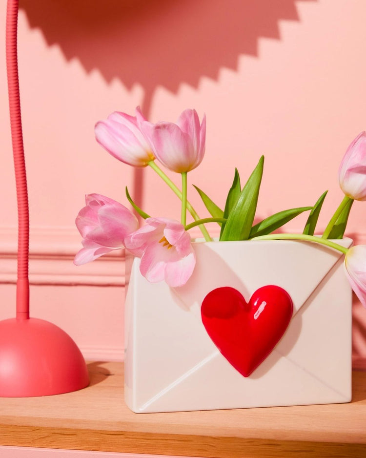 Vase en céramique en forme de cœur sur fond neutre