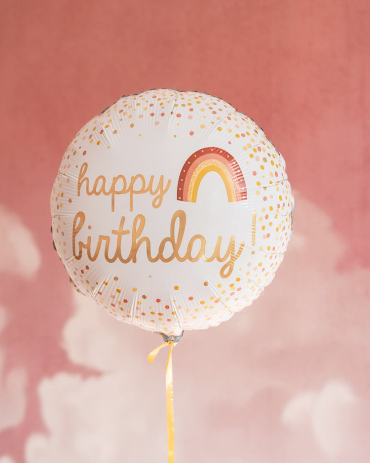 Ballon arc-en-ciel 'Happy Birthday' avec motifs festifs.