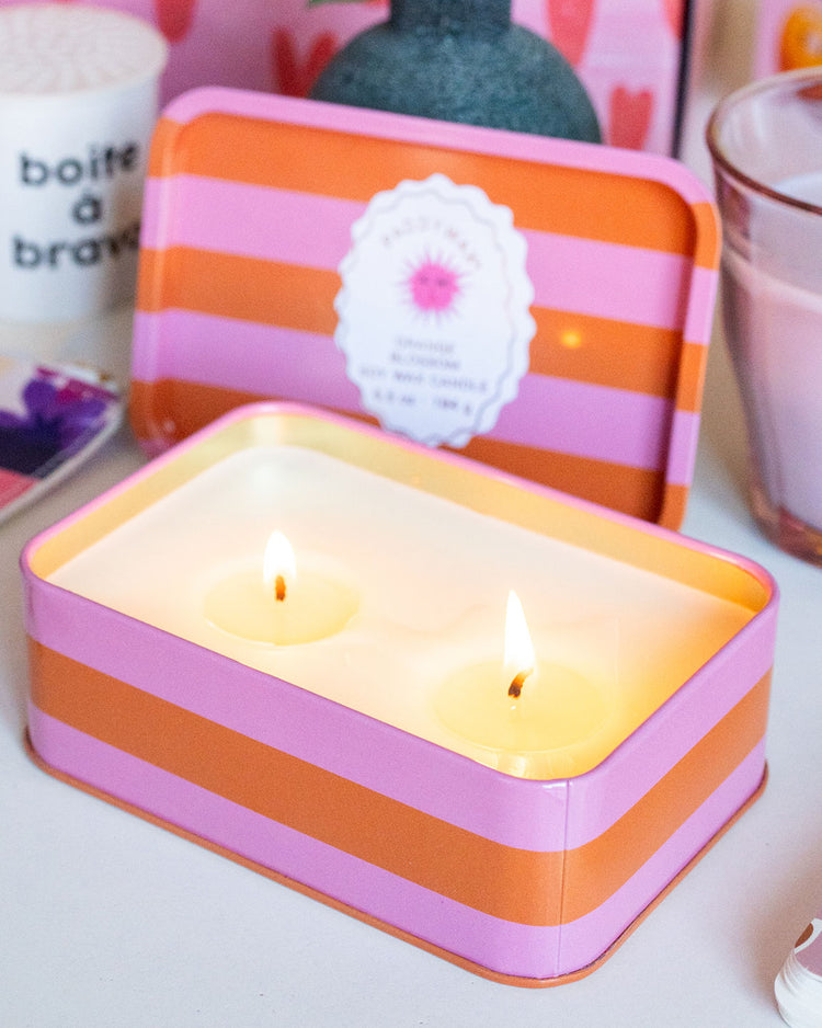 Bougie Orange Blossom avec rayures orange et rose, deux mèches.