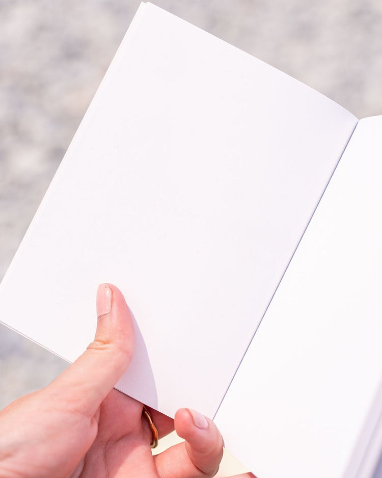 Carnet ouvert montrant ses pages blanches intérieures.