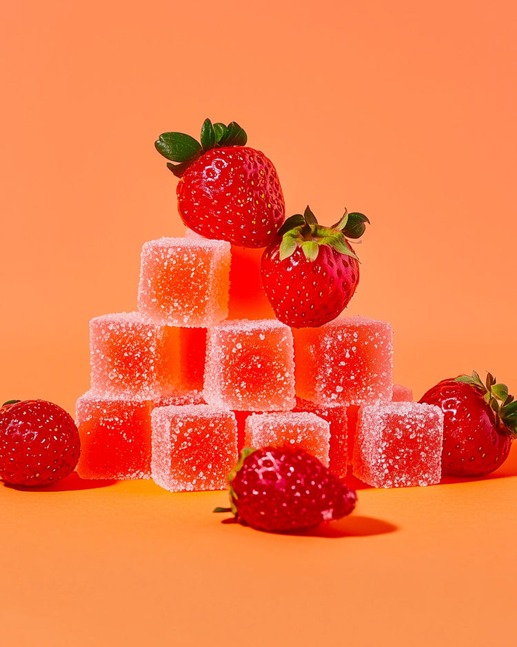 Gummies au CBD en forme de fraise des bois, texture brillante.
