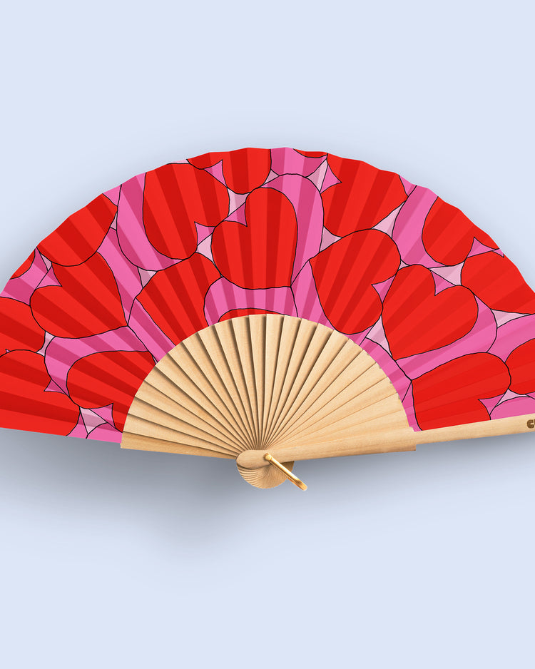 Éventail déployé avec motifs de cœurs roses et rouges