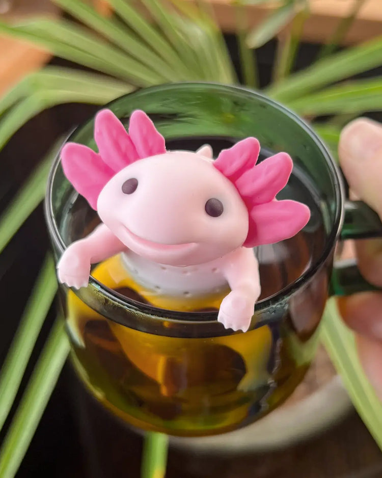 Infuseur à thé axolotl suspendu au bord d'une tasse