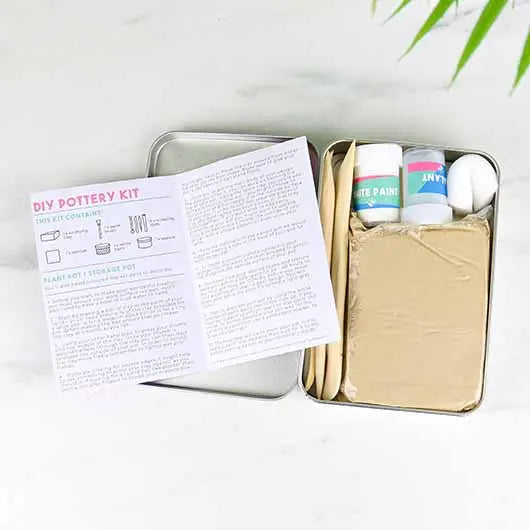Kit DIY poterie avec outils et argile sur fond neutre