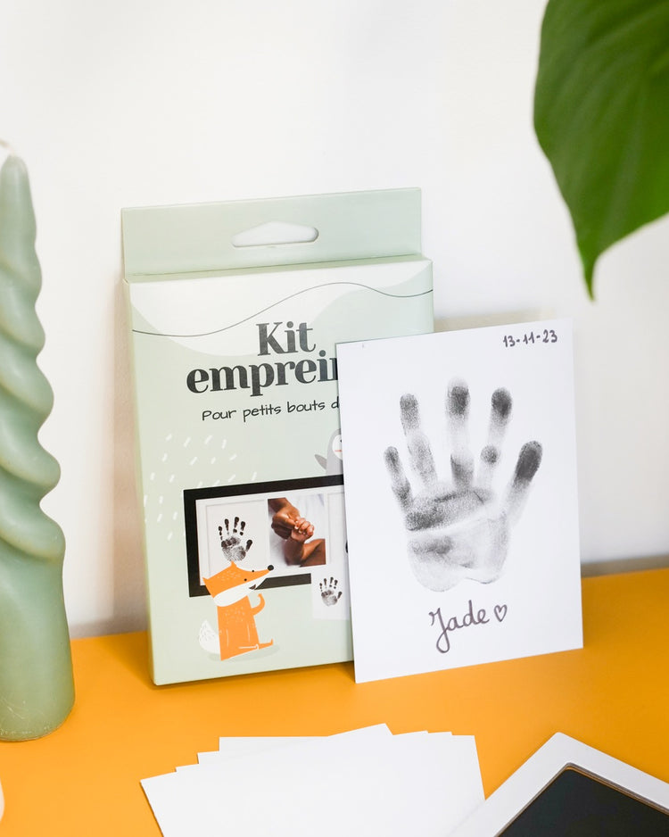 Kit d'empreinte de bébé avec détails des empreintes sur fond clair.