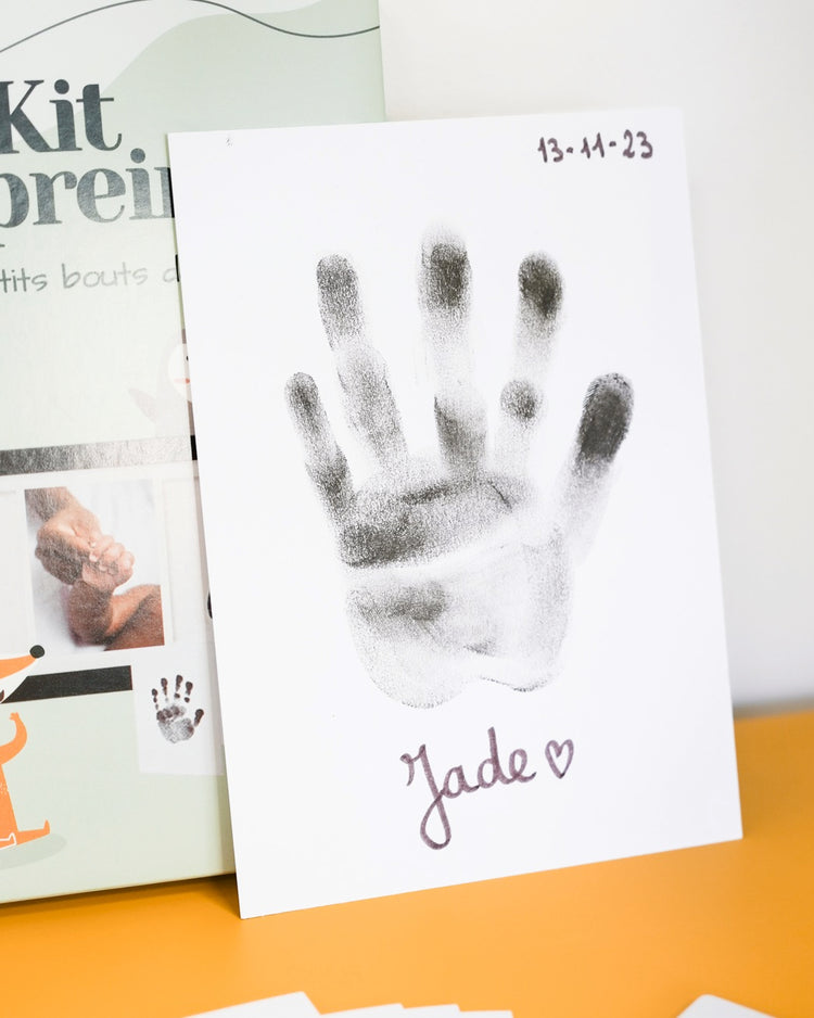 Kit d'empreinte de bébé avec détails des empreintes sur fond clair.