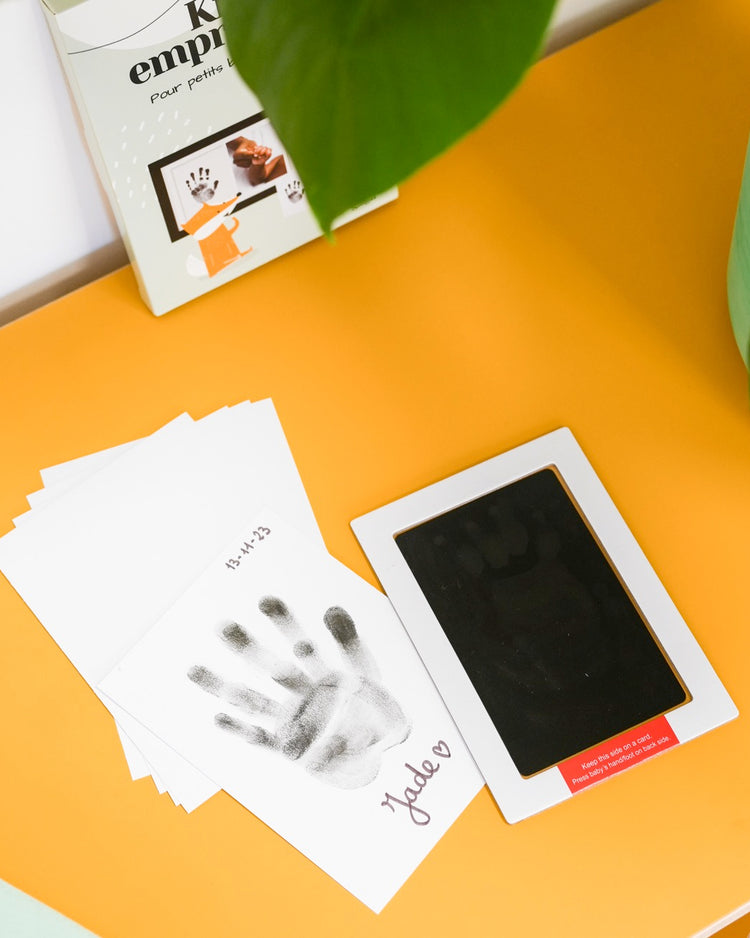 Kit d'empreinte de bébé avec détails des empreintes sur fond clair.