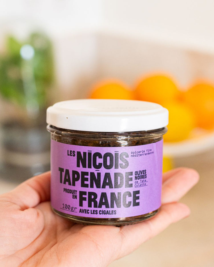 Pot de tapenade noire avec texture crémeuse et olives visibles.