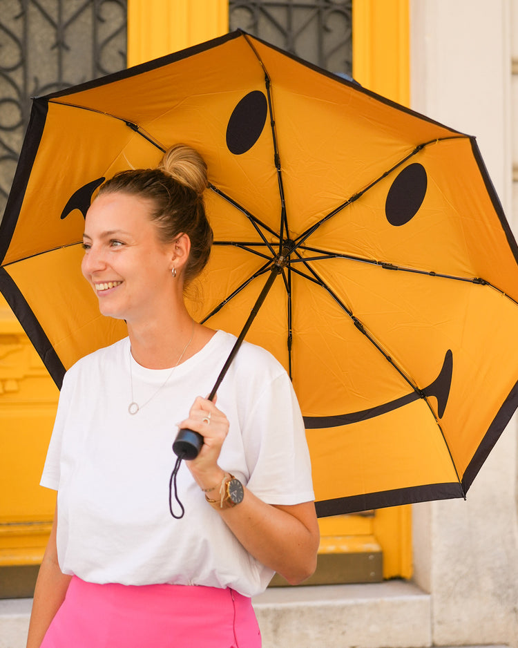 Parapluie Smiley ouvert, motif joyeux à l'intérieur.