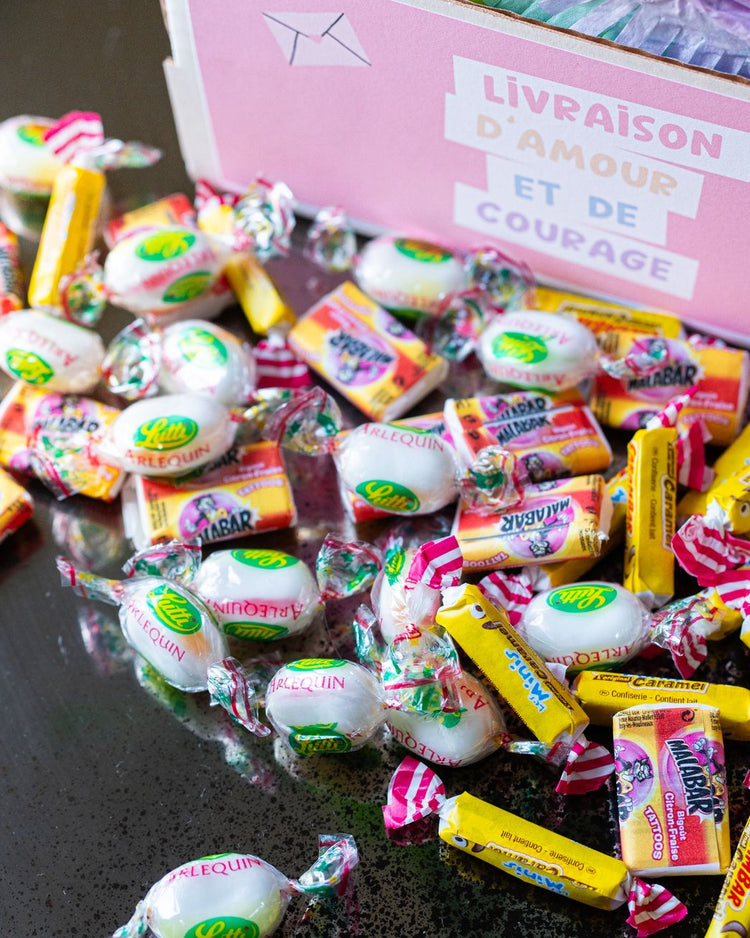 Piñata arc-en-ciel vue de côté avec bonbons colorés visibles.