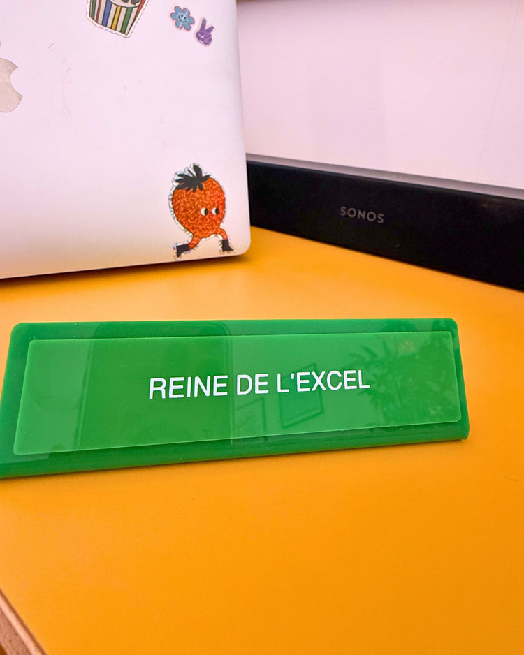 Plaque de bureau verte 'Reine de l'excel' sur un bureau