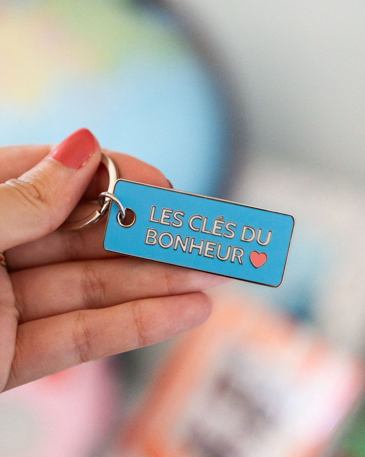 Porte-clés en métal avec inscription sur fond blanc
