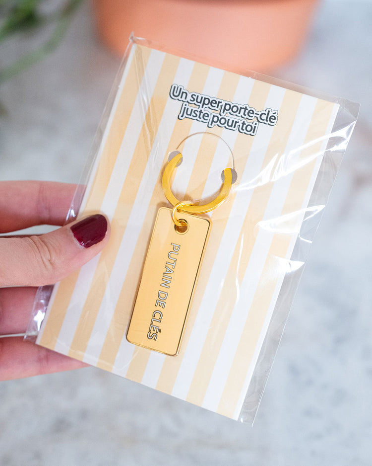 Porte-clé avec inscription humoristique sur fond clair.