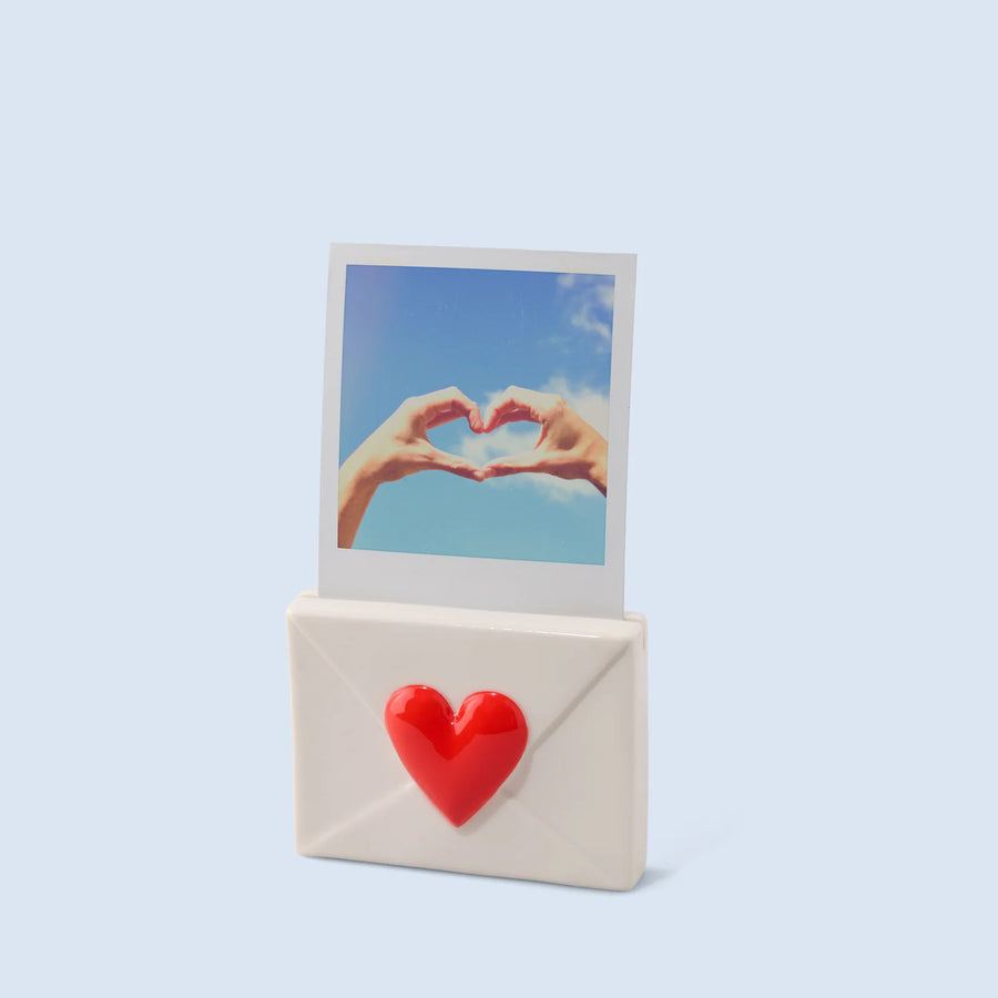 Porte-photo en céramique en forme de coeur sur une étagère