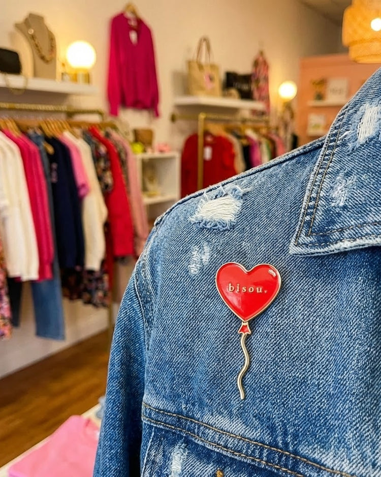 Pin 'Bisou' avec ballon cœur rouge et texte doré sur fond clair