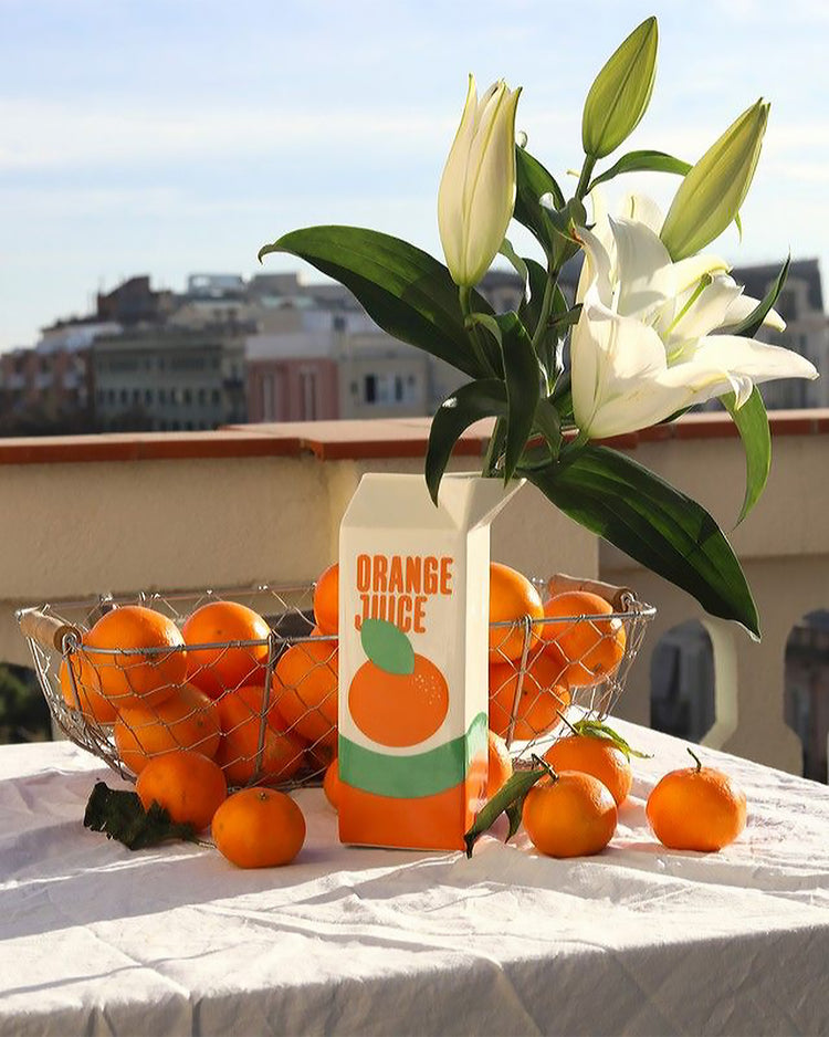 Vase en forme de brique de jus d'orange, vue de face.