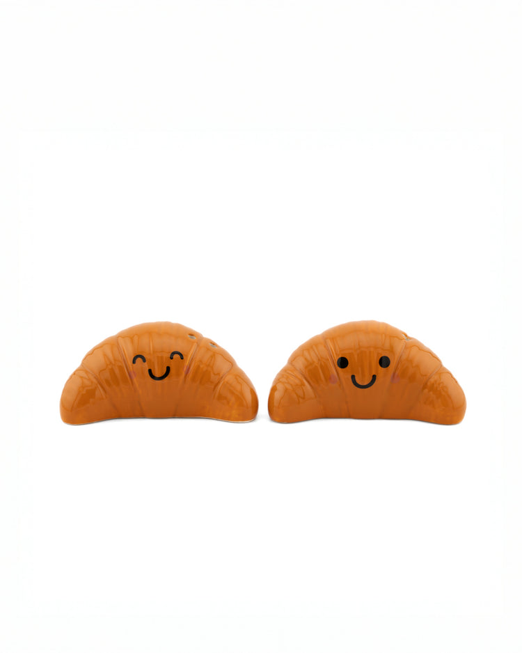 Salière et poivrière en forme de croissants sur fond clair