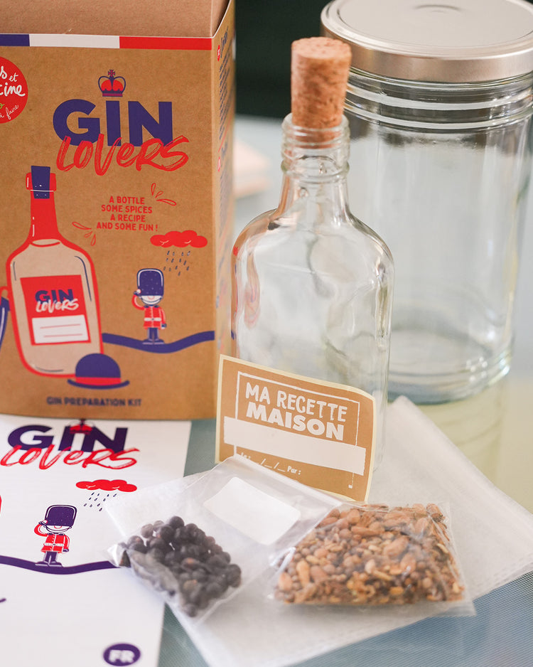 Kit DIY pour gin avec ingrédients et accessoires sur fond clair.
