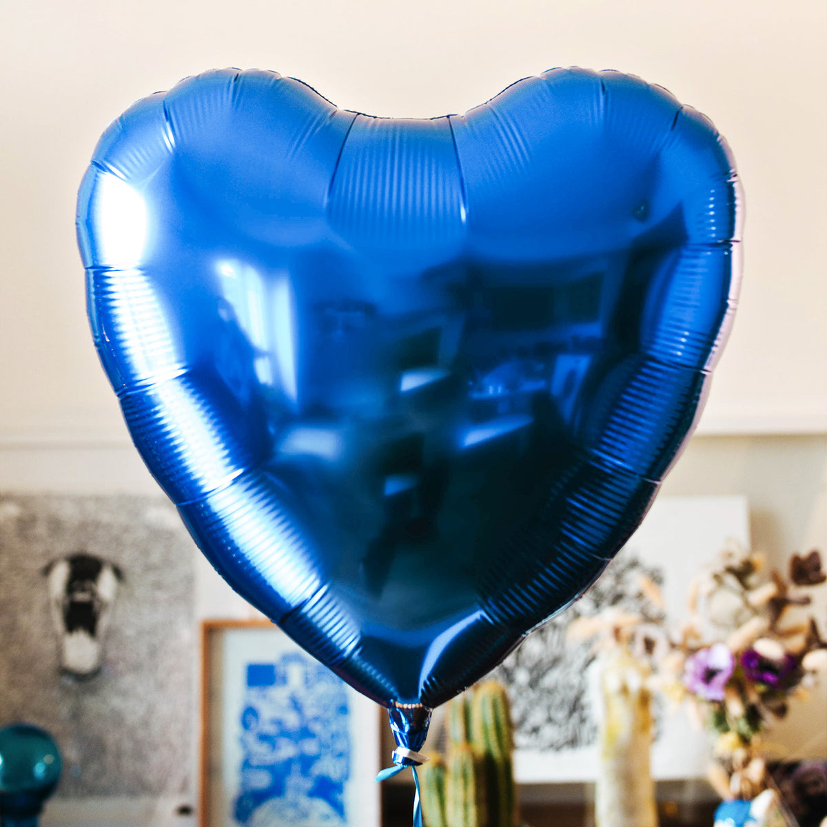 Ballon coeur bleu saphir sur fond blanc.