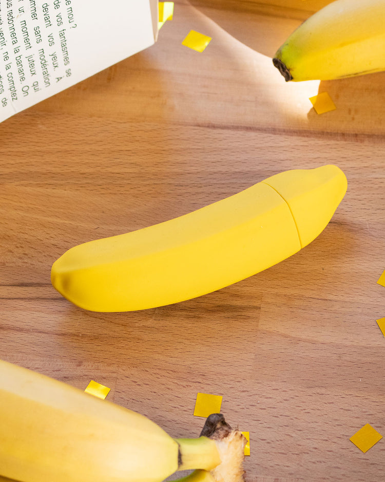 Sextoy vibrant en forme de banane, vue de côté avec texture lisse.