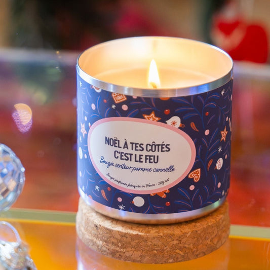 Bougie festive avec étiquette humoristique sur fond neutre