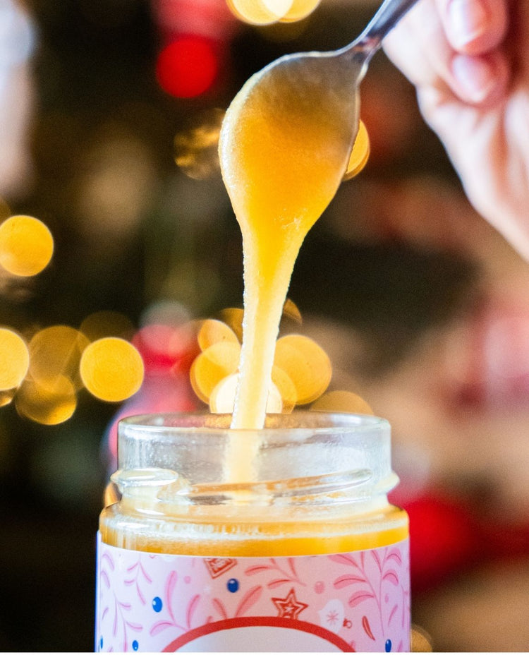 Pot de miel décoré pour Noël avec un ruban festif