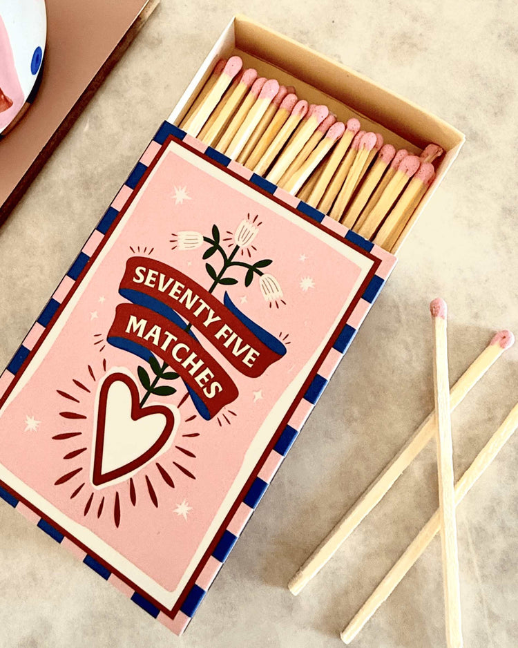 Coffret vintage d'allumettes avec têtes roses et décor romantique.