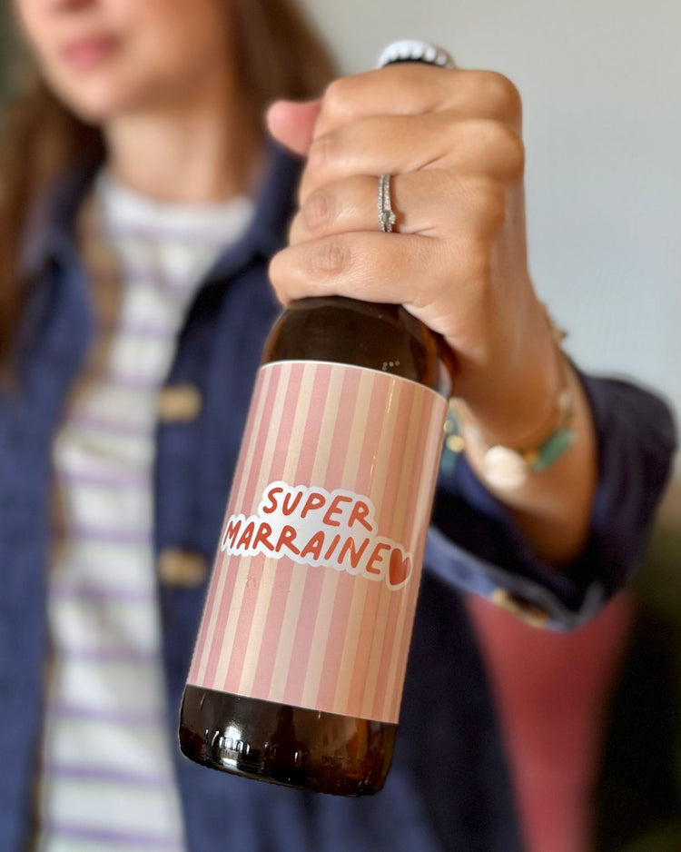 Bière Super Marraine avec mousse généreuse et étiquette dorée.