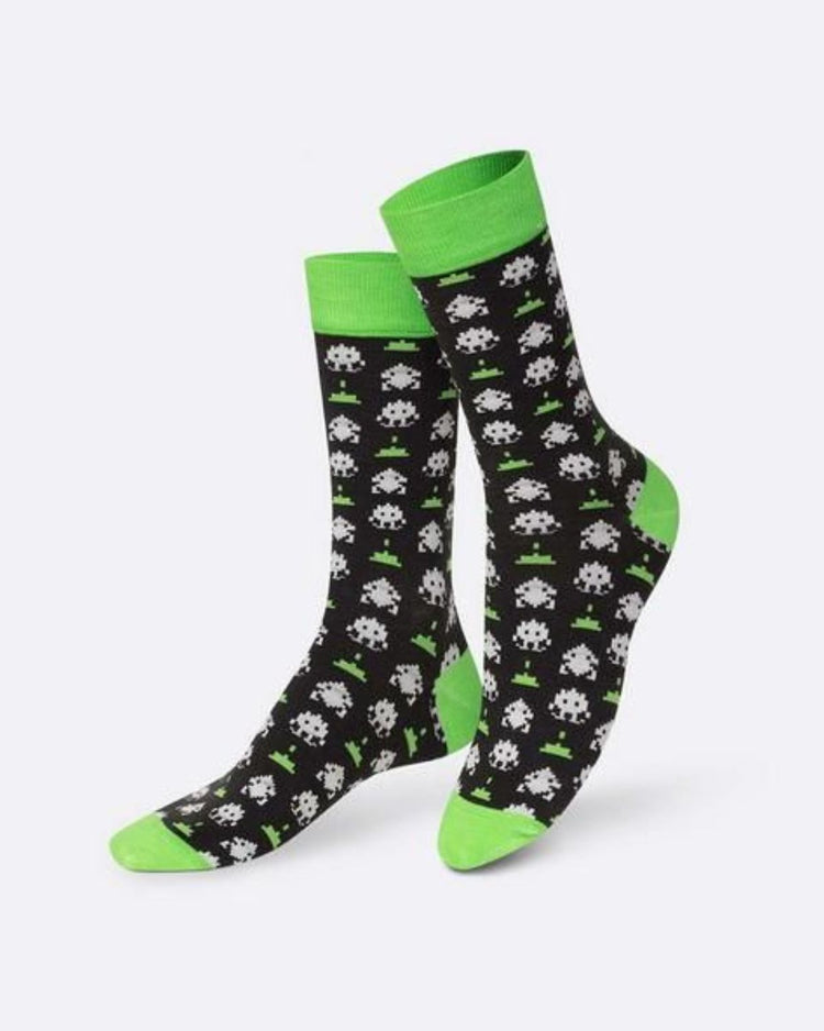 Chaussettes avec motifs de jeux vidéo vintage et aliens pixelisés.