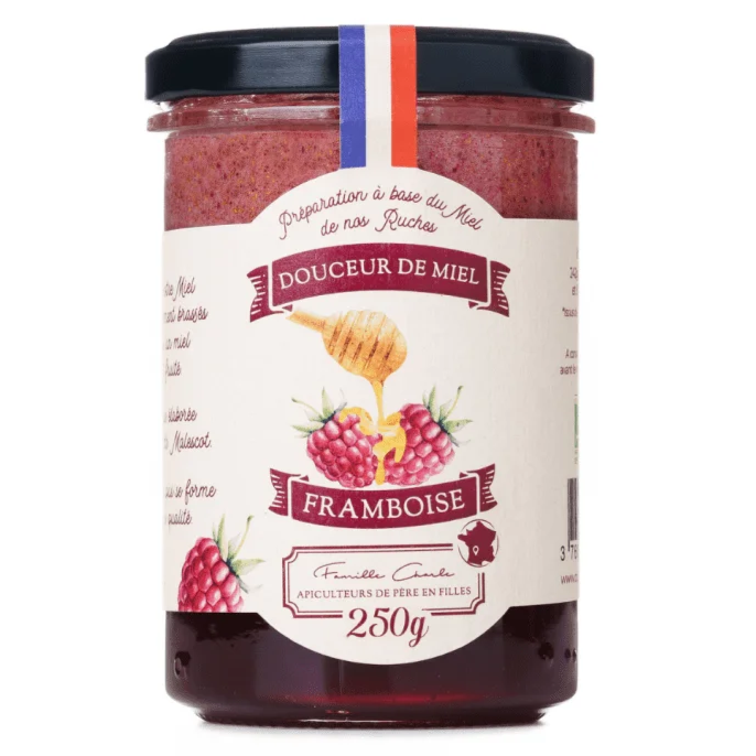 Pot de miel framboise bio avec texture dorée et fruits visibles.