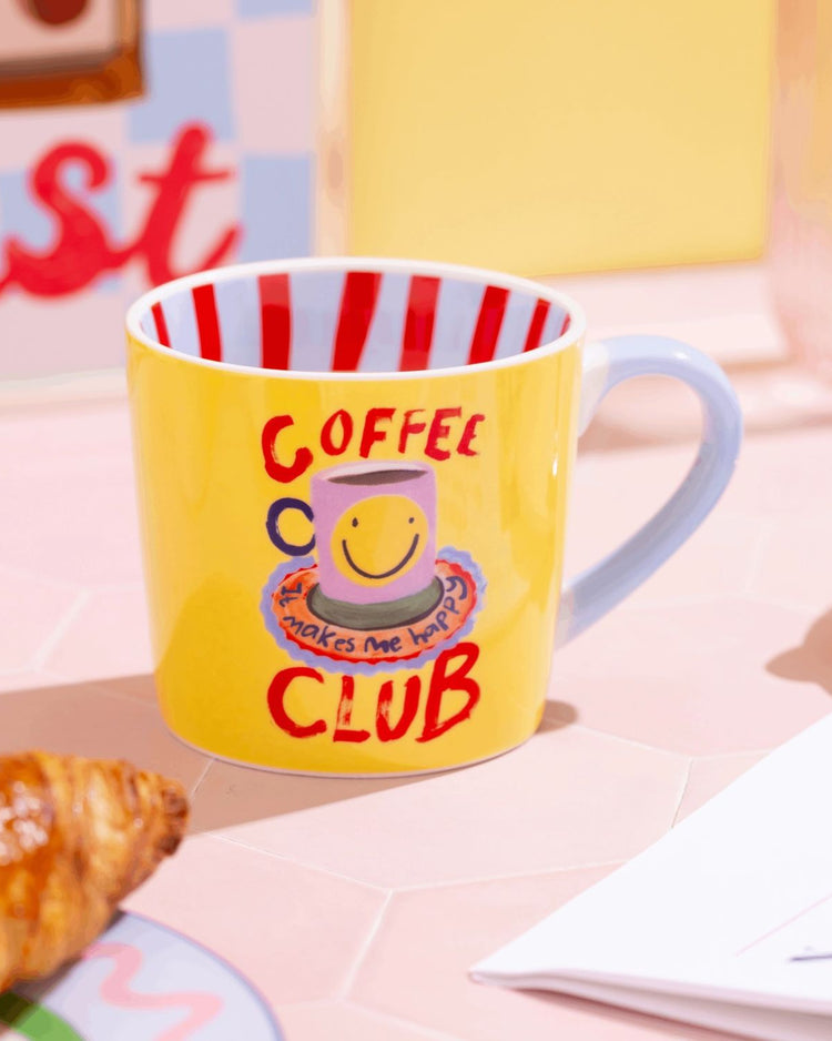 Mug Coffee Club avec message coloré sur fond blanc.