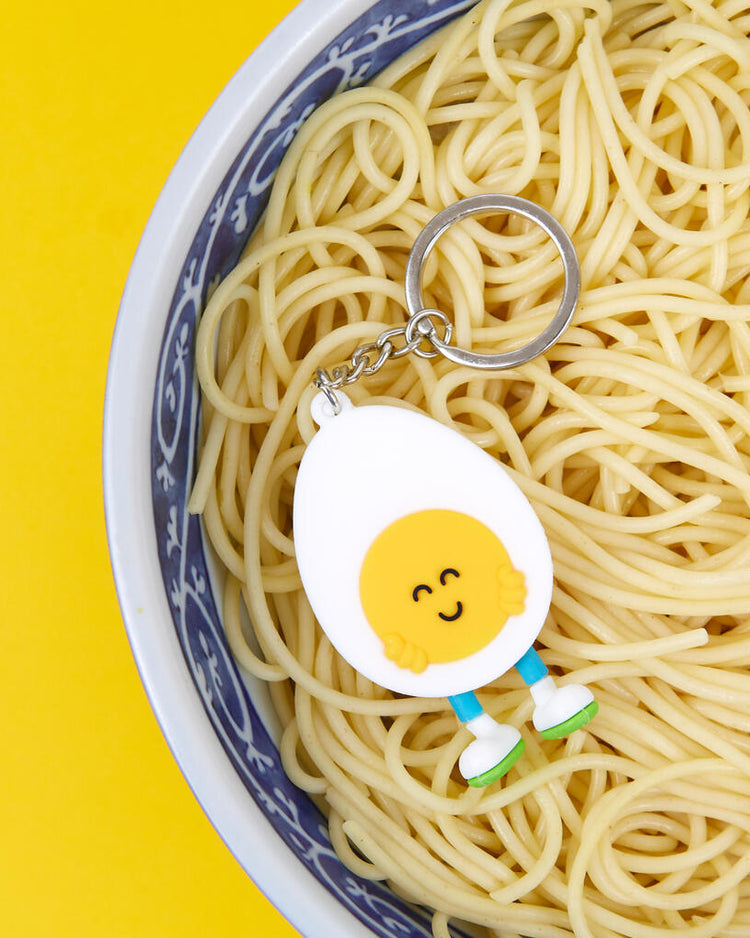 Porte-clés en forme d'œuf souriant sur fond clair