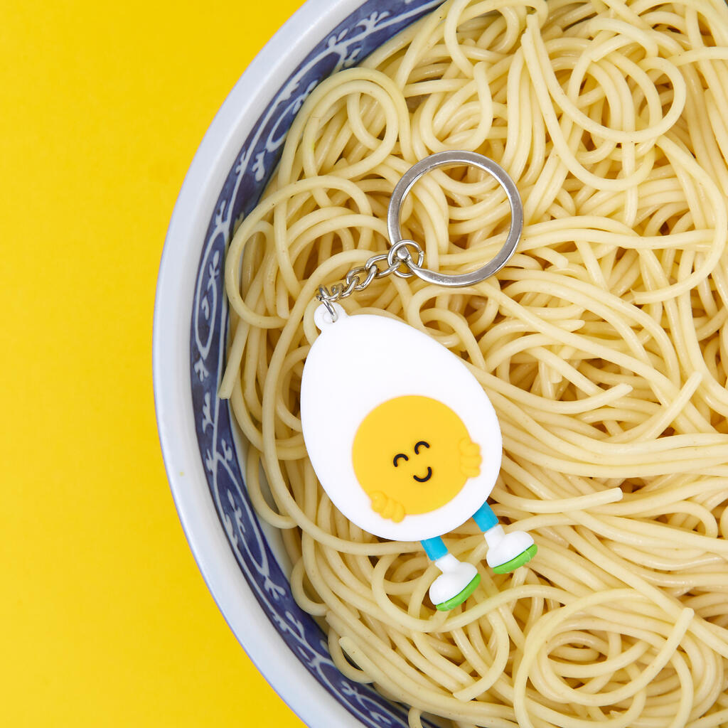 Porte-clés en forme d'œuf souriant sur fond clair