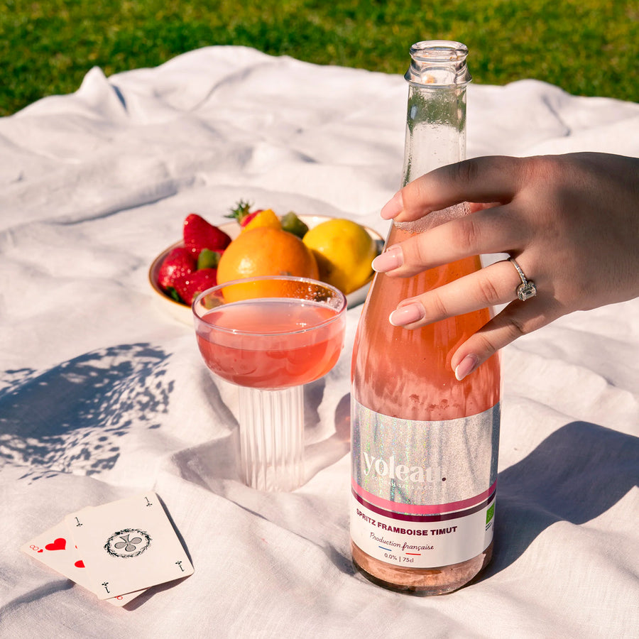 Bouteille de spritz framboise sur fond clair, étiquette colorée