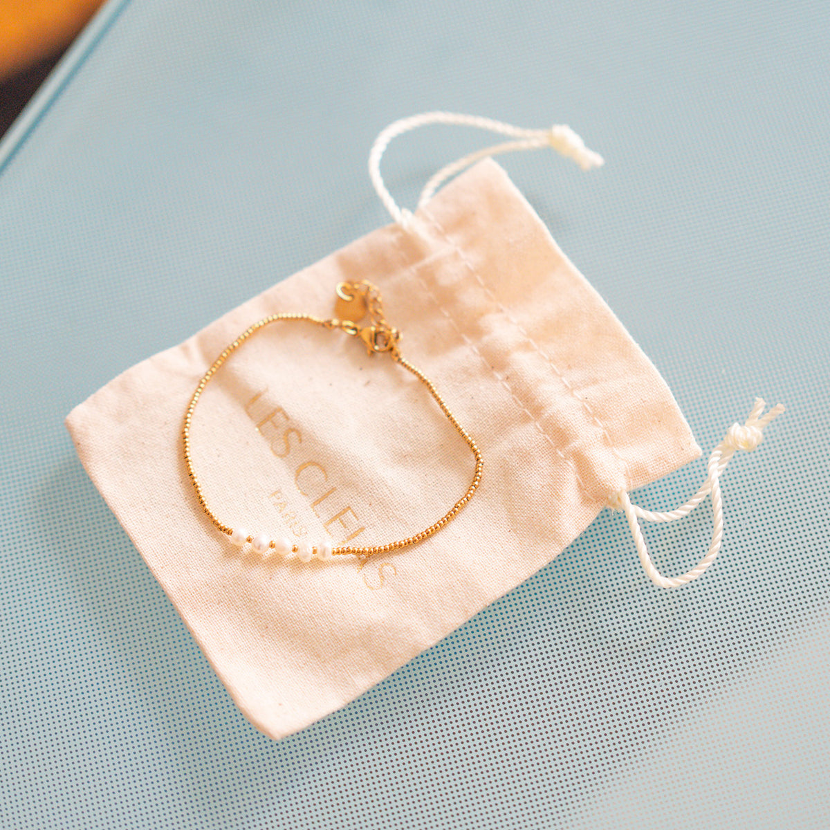 Bracelet délicat avec perles blanches sur chaîne dorée