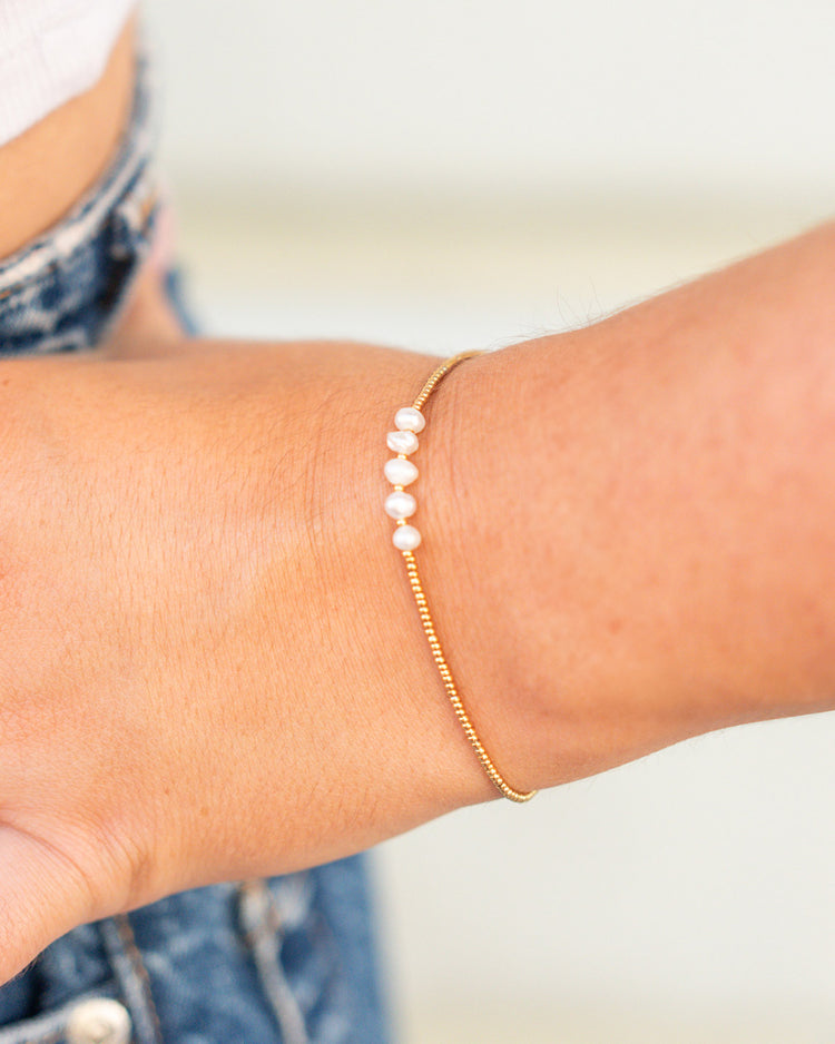 Bracelet délicat avec perles blanches sur chaîne dorée