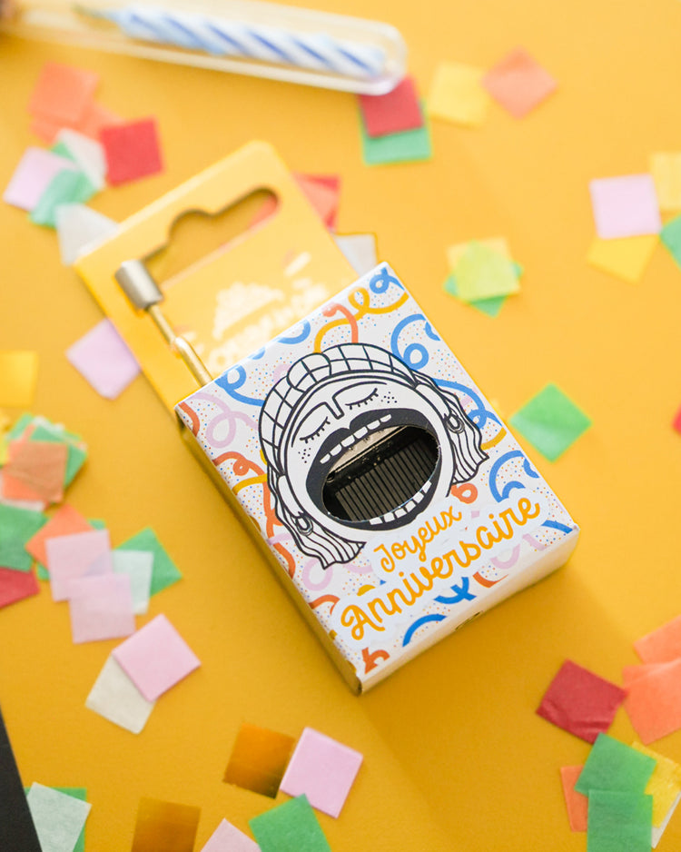 Boîte à musique avec motif de gâteau d'anniversaire coloré.