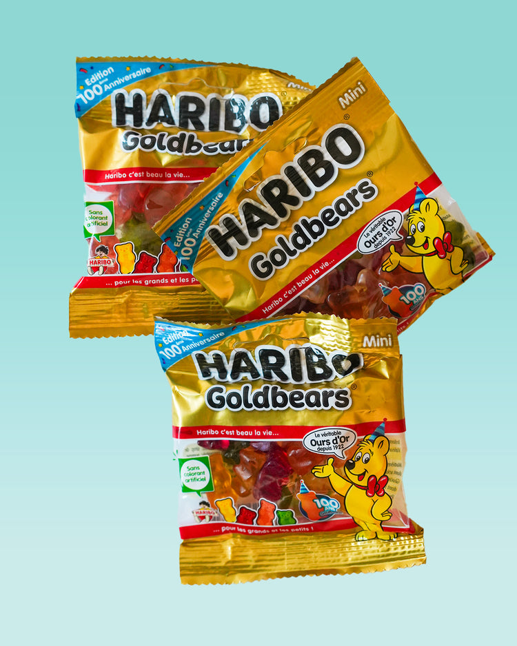 Cinq sachets d'oursons Haribo avec motifs colorés.