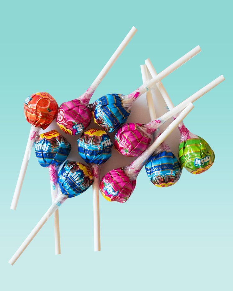 Mini Chupa Chups colorés en assortiment sur fond blanc