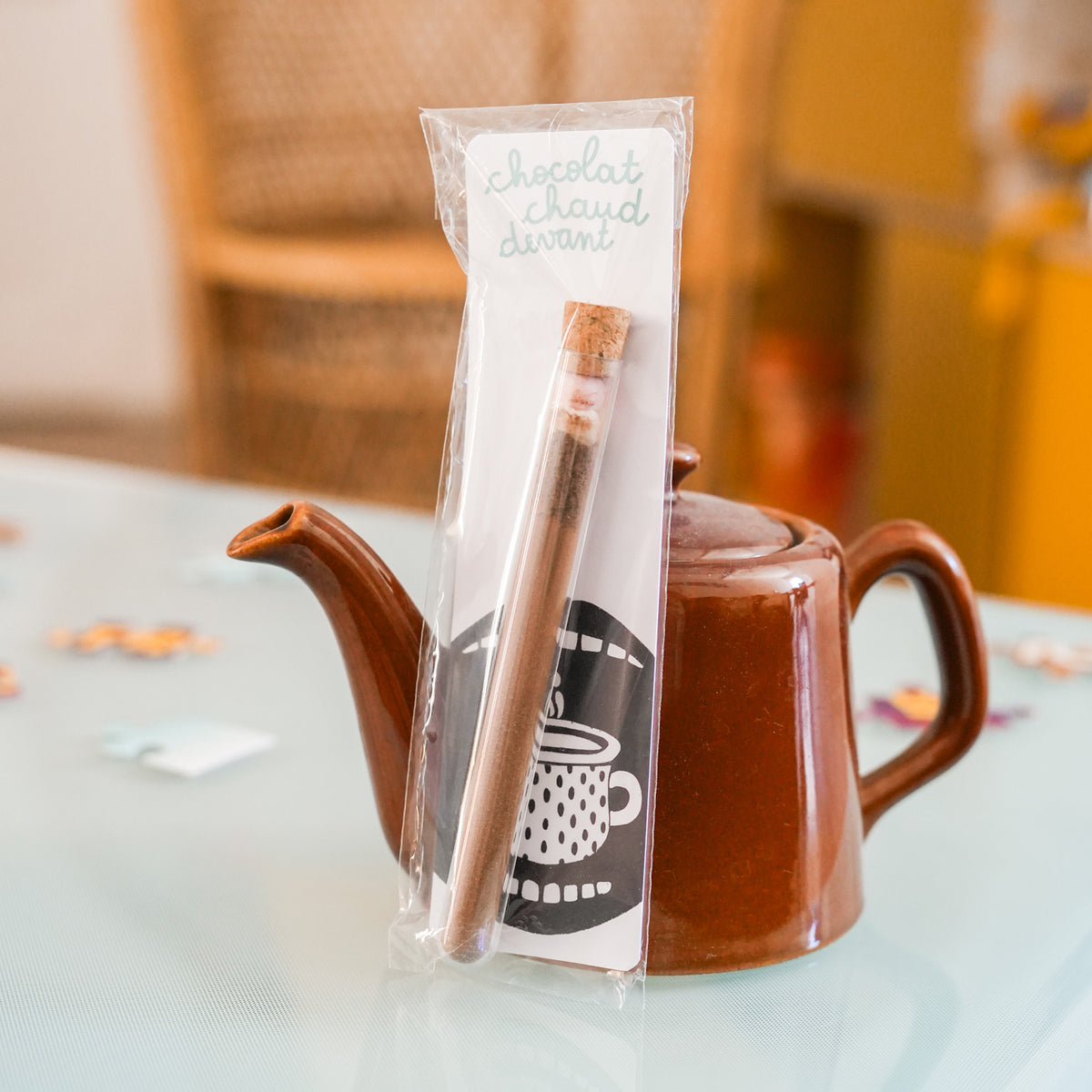Tube à chocolat chaud avec étiquette colorée et bouchon doré.