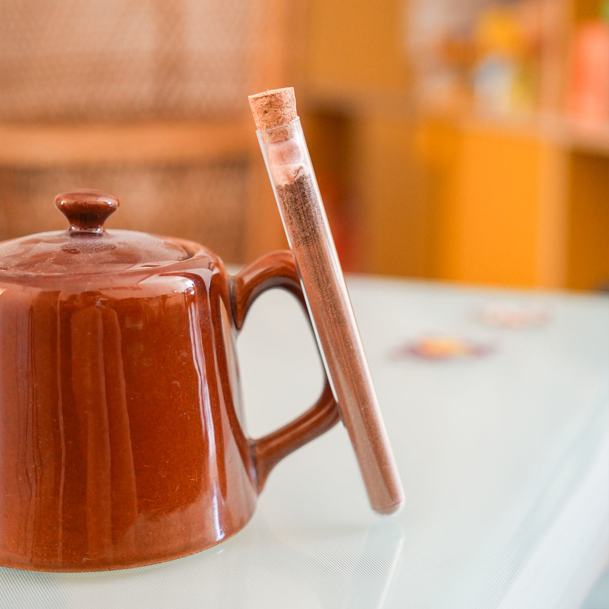 Tube à chocolat chaud avec étiquette colorée et bouchon doré.