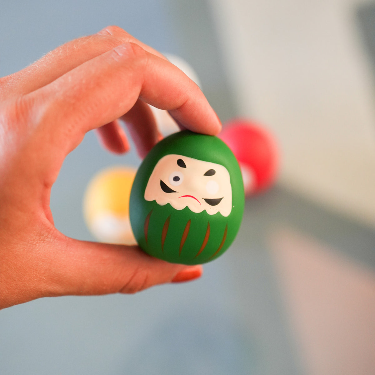 Daruma japonais en vue rapprochée, détails colorés et expressifs.