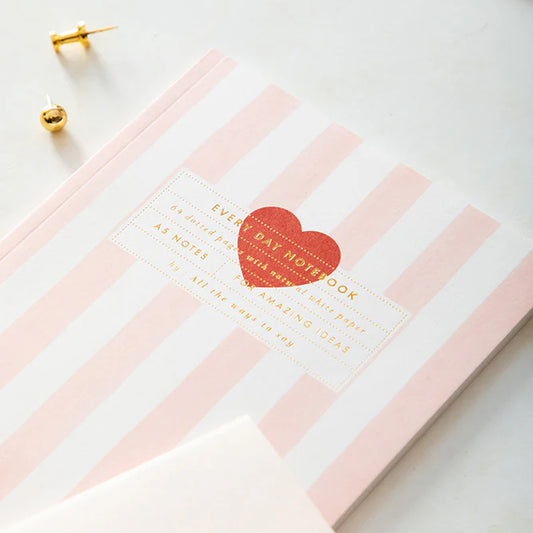 Carnet rayé rose avec motif cœur rouge sur la couverture