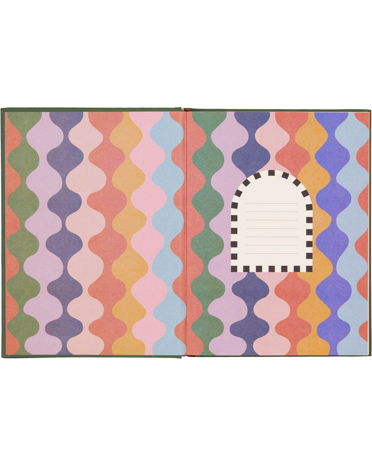 Carnet avec motif soleil sur fond rose vif, ouvert sur une table