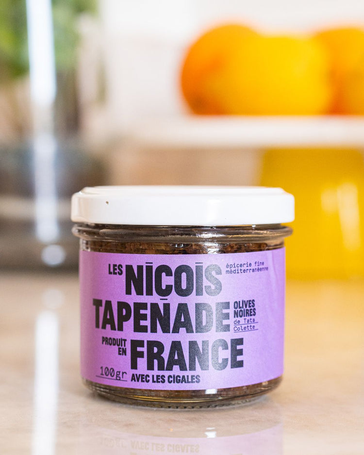 Pot de tapenade noire avec texture crémeuse et olives visibles.